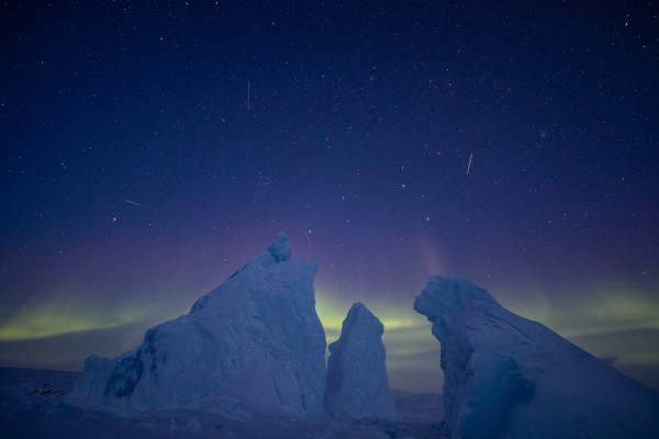 northern lights above white icebergs