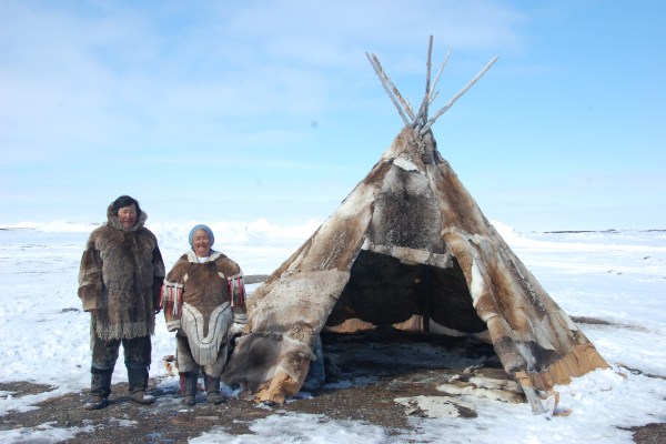 Nunavut citizens posing beside a teepee
